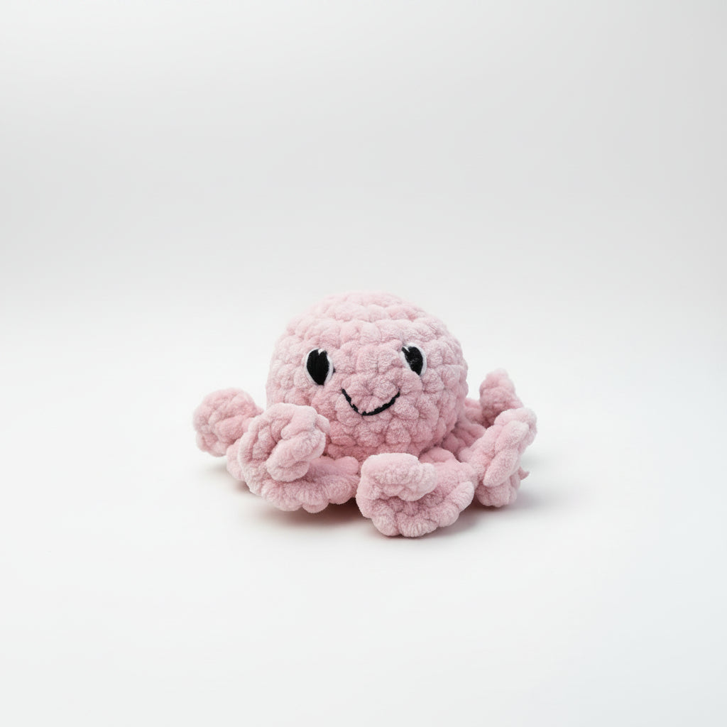 Pink plush octopus toy held in a hand with a blurred natural background
