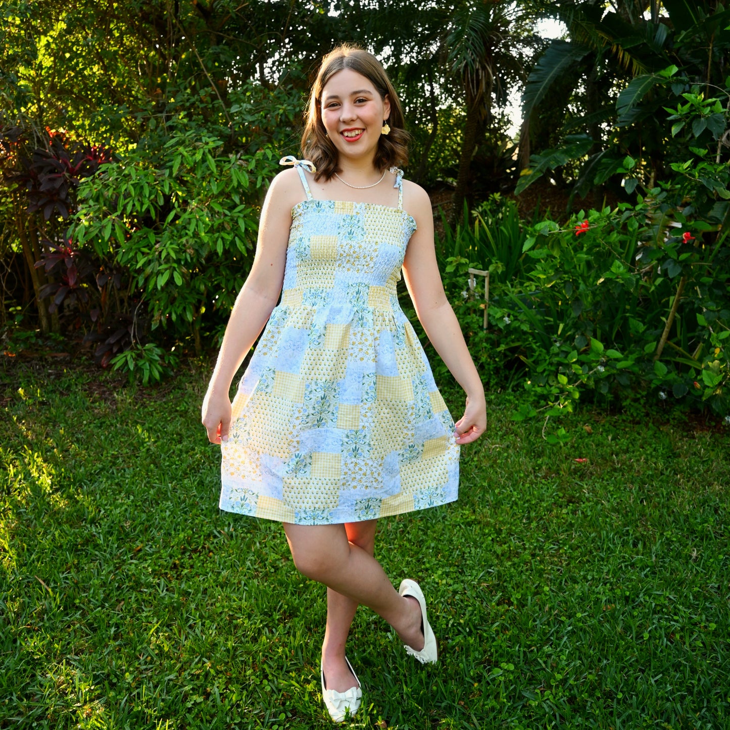 Woman in a patterned dress standing in a garden